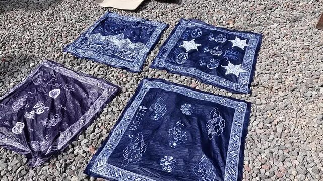 Freshly dyed cotton batik fabric drying in the sun, traditional Indonesian textile craft process in 4K