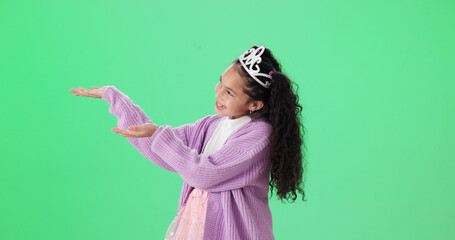 Naklejka premium Costume, pointing and princess with girl on green screen background for dress up announcement. Crown, hand gesture and smile of female child isolated on studio mockup space for deal or notification