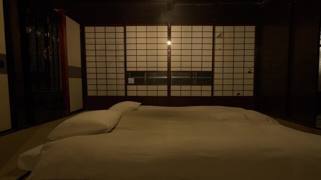 Dark wood in traditional Japanese bedroom with futons and shoji doors