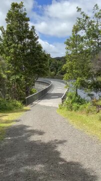 A scenic view of the Upper Reservoir dam in Cascade Kauri Walk, Waitakere, Auckland, New Zealand. The dam provides water and recreation, with a path for walking and enjoying nature.