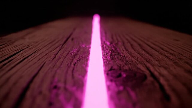 Pink neon light beam illuminating rustic dark wood surface with textured grain