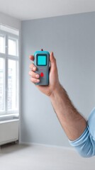 Hand holding a digital measuring device in a bright room with large windows, showcasing modern technology and home improvement tools for precise measurements