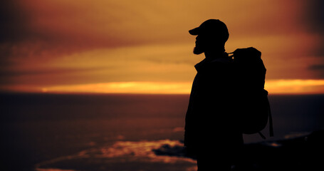 Obraz premium Sunset, hiking and silhouette of man on holiday, reflection and vacation with view outdoor. Trekking, backpacking and person in nature for adventure, travel or thinking while sightseeing with space