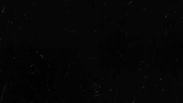 Black surface with scattered white dust and linear scratches