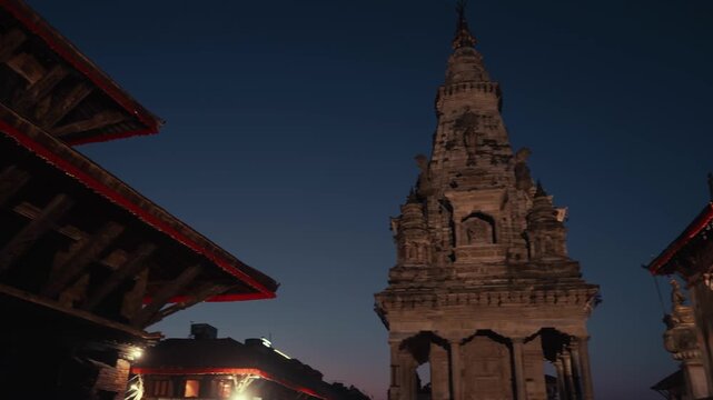 Traditional historic pagoda temples around Bhaktapur Durbar Square as evening lights turn on. Nepal
