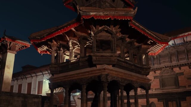 Temples and historic buildings at Bhaktapur Durbar Square lit by warm lights after sunset. Nepal