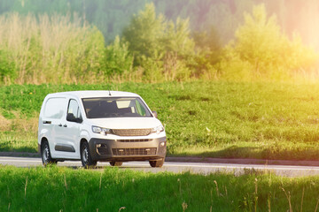 Fototapeta premium White van driving on a sunny day in nature
