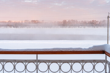 Naklejka premium Snow on the balcony railing after heavy snowfall on background of winter dawn. 