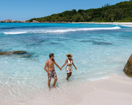 Couple enjoying a romantic walk on Anse Cocos beach in La Digue, Seychelles
