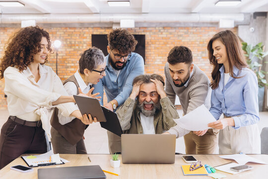 Overwhelmed manager experiencing stress and pressure from demanding colleagues in a chaotic office meeting, feeling burnout
