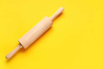 Rolling pin on yellow background