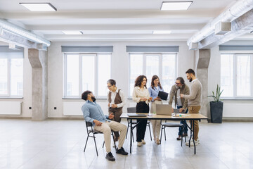 Fototapeta premium Diverse business team collaborating and discussing strategy during an informal office meeting