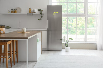 Interior of kitchen with modern fridge, table and shelf