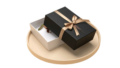 Black gift box with gold ribbon on a white box atop a circular tray