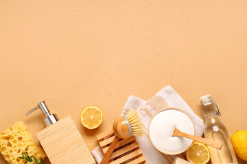 Baking soda with vinegar, lemons and cleaning supplies on orange grunge background
