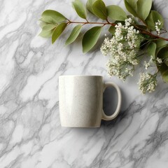 Beige mug, foliage, and white flowers on gray marble