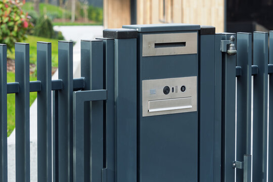 Modern metal mailbox with gate intercom at private house entrance, clean exterior detail for security and delivery themes.