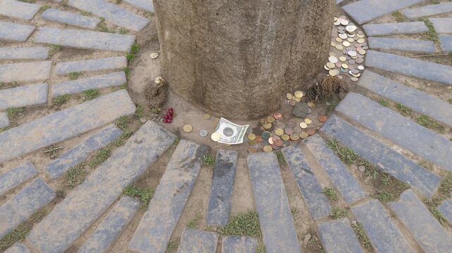 Coins And Paper Bills On Stone Of Destiny (Lia Fail) At The Hill Of Tara, Used As A Coronation Stone For The High Kings Of Ireland. - closeup shot