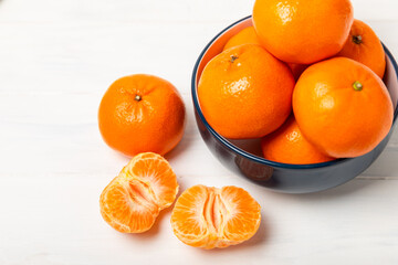 Fresh, ripe, juicy tangerines on the table. Whole and halved tangerines, clementines with green leaves. Citrus fruits. Tangerine or clementine. Fresh oranges. Vitamin C. Natural vitamin. Orange. 