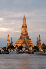 Fototapeta premium Charming scene of Wat Arun Temple shining beautifully against the evening sky