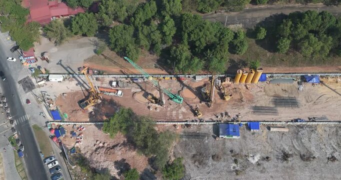 Top down aerial view of an active construction site with bored piling rigs and heavy machinery.