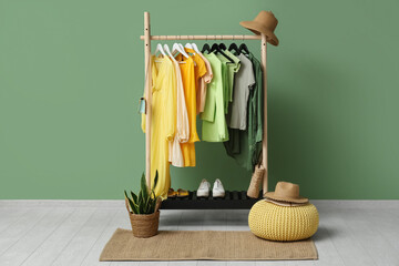 Female clothes hanging on rack against green wall
