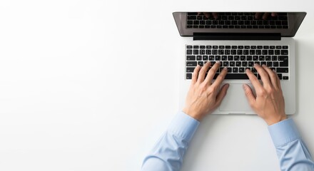 Person typing on laptop keyboard with both hands on a white desk viewed from above