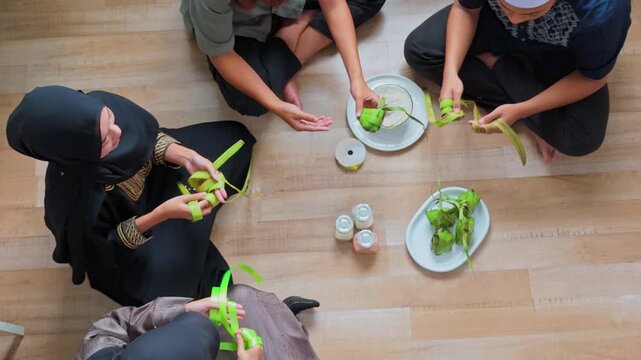 Top-down view of people preparing ketupat snacks for Eid al-Fitr or Ramadan celebrations