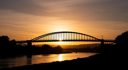 Obraz premium Silhouette of a bridge at sunset.