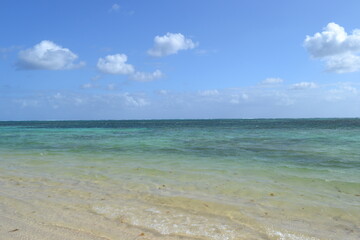 Fototapeta premium Turquoise Sea Coast with Clear Water and Blue Sky with Clouds