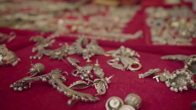 Ethnic Indian silver ornaments arranged on red background