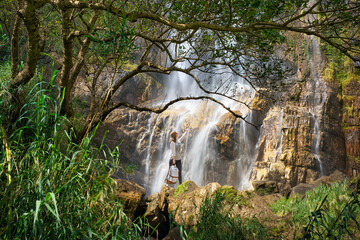 Woman Hiker Embracing highest Waterfall's Spray Diyaluma Falls, Sri Lanka. Travel Adventure Concept
