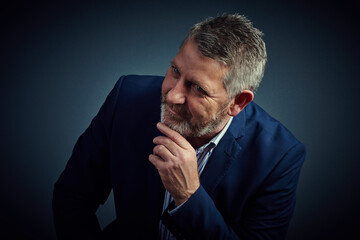 Fototapeta premium Decision, planning and thinking with business man in studio for company development or vision. Corporate, future and question with mature employee on dark background for brainstorming or solution