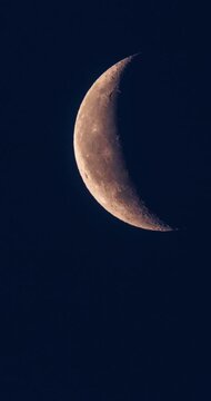 Timelapse of a waxing crescent Moon moving across a dark night sky. Detailed lunar surface with visible craters and terminator line, illustrating the lunar phase cycle and astronomical motion.