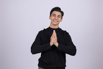 Young man in black turtleneck holding hands together