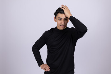 Man in black turtleneck touching his head in thought