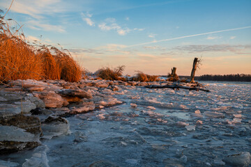 The shores of the lake frozen in the light of the rising sun