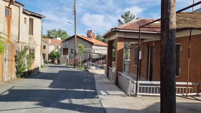 Narrow street in Cyprus village with parked cars