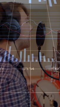Vertical video: Male singer leaning into mic, singing for recording, HUD charts over mic and pop