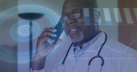 Speaking senior Black doctor holding phone and stethoscope, viewing HUD in clinic, wearing lab coat