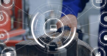 Holding blue-jacketed hand filing workpiece with file in bench vise, shop HUD showing laptop icons