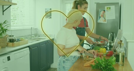 Slicing radishes on board in kitchen, white tee in jeans, partner stirring pan, gold heart overlay