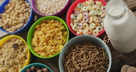 Displaying large light blue bowl of bran sticks on wooden table, with milk bottle, numeric overlays © vectorfusionart