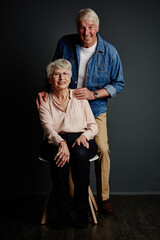 Fototapeta premium Love, portrait or elderly couple in studio with smile, romantic connection or trust in retirement. Happy, old man and woman on gray background with security, commitment and support in relationship.