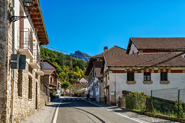 Strolling through Isaba in Roncal valley, Pyrenees, Navarre in Spain with brownish tiled roofs of residential buildings