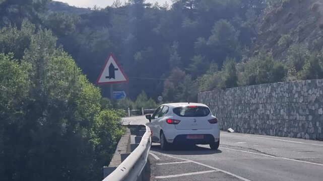 Curvy mountain road with hairpin sign in Cyprus forest