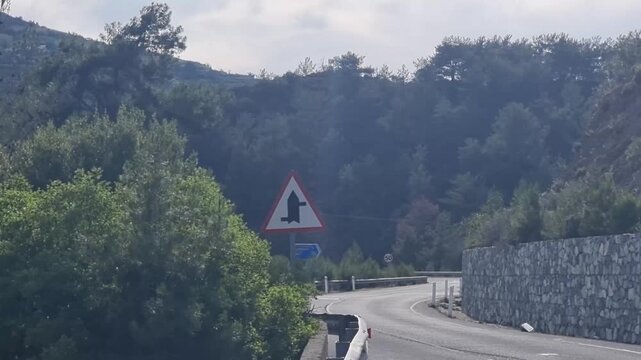 Curvy mountain road with hairpin sign in Cyprus forest