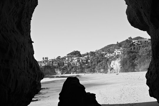 View from a coastal cave framing the sandy shoreline and cliffs at 1000 Steps Beach in Laguna Beach, Orange County, California.