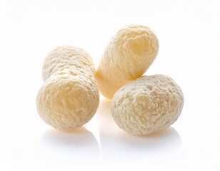 Obraz premium Delicious and crispy small white snack pieces, perfectly isolated on a bright reflective surface, showcasing their unique texture and appealing golden-white hue