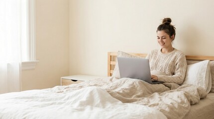 Young woman working on laptop while sitting in cozy bed at home  